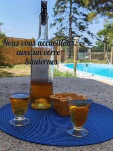 a bottle of beer and two glasses on a table at Chambre du merle in Illats +22 photos