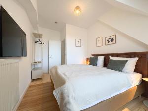 a bedroom with a bed and a flat screen tv at Apartments am Alten Markt in Stralsund