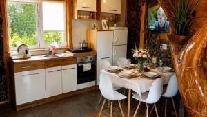 a kitchen with a table with chairs and a white refrigerator at Bieszczadzka Chatka Gosia - Off Road , Quady , Jazda Konna in Czarna