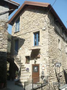 an old stone house with a staircase leading up to the door at La Pecora Nera in Rocchetta Nervina