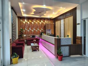 a lobby with a reception desk and red chairs at Kamaksha Palace in Sundarnagar