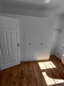 an empty room with white cabinets and a door at Old appartment in Helsingborg
