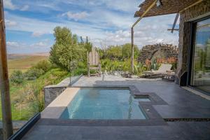 a swimming pool with a chair and a patio at Diar illi in Touama