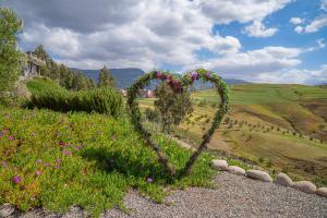 a heart shaped arch in a field of flowers at Diar illi in Touama +78 photos
