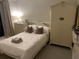 a bedroom with a white bed with pillows and a dresser at Belle-Vue in Truro