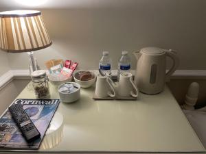a table with a lamp and a book and water bottles at Belle-Vue in Truro