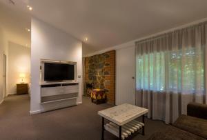 a living room with a flat screen tv and a couch at Bright Mystic Valley in Bright