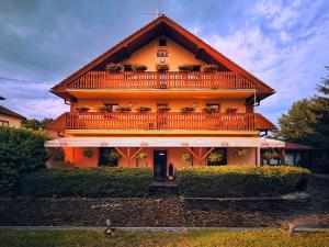 a large orange house with a large balcony on it at Penzion UNA in Liptovský Ján