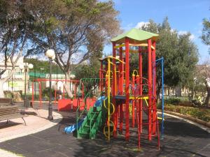 a playground in a park with a colorful play structure at Valletta Gateway Maisonette in Valletta