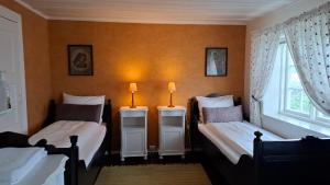 two beds in a room with two lamps on them at Handelsstedet Forvik in Vevelstad