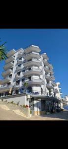 a large white apartment building on the beach at Blue Waves Hotel & Suites in Sarandë
