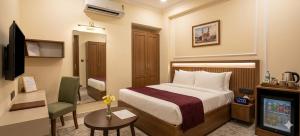 a hotel room with a bed and a television at Hotel Aroha Stayz At Sector 44 Noida in Noida