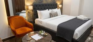 a hotel room with a bed and a chair and a table at Hotel Aroha Stayz At Sector 44 Noida in Noida +32 photos