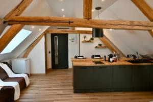 an attic kitchen with wooden ceilings and wooden floors at Superbe Loft proche Troyes & Parking facile in Arcis-sur-Aube
