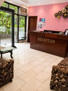 a reception desk in a lobby with a pink wall at Hotel Swisston Palace in New Delhi