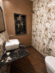 a bathroom with a sink and a wall mural at Hotel Swisston Palace in New Delhi +20 photos