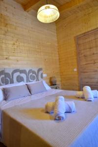 a bed with two pillows and a dog laying on it at Casa rural El Pinton in Gálvez +20 photos