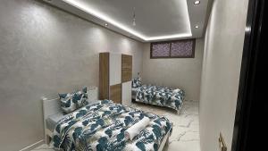 a bedroom with two beds with blue and white sheets at Manifique renovated apartment Marrakech in Marrakesh