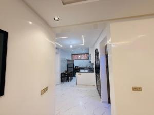 a kitchen and a living room with white walls at Manifique renovated apartment Marrakech in Marrakesh