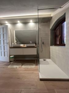 a bathroom with a glass shower and a sink at Il Piccolo Aranceto in Motta SantʼAnastasia +24 photos
