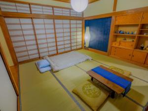 a small room with a bed and a table at 天然温泉付 一棟貸し最大12名 近隣施設事前予約で バーベキュー 花火 和羽灯屋 ナウヒヤ in Fuefuki