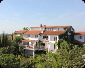 a large white house with red roof at Gargamelo Pension in Poreč