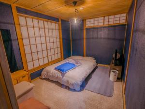 a small room with a bed in the corner at 天然温泉付 一棟貸し最大12名 近隣施設事前予約で バーベキュー 花火 和羽灯屋 ナウヒヤ in Fuefuki +23 photos
