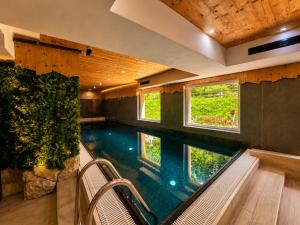 a swimming pool in a house with two windows at Park Hotel Avisio in Soraga