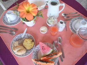 una mesa rosa con platos de comida. en Hotel Pousada Castanheiras do Village, en Porto Seguro
