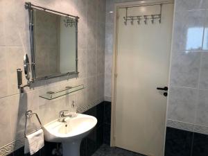 a bathroom with a sink and a mirror and a shower at Stylish Apartment with Spacious Terrace in Aglantzia +8 photos