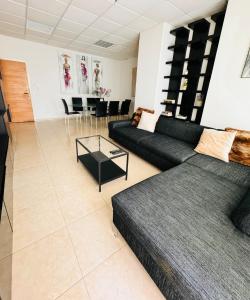 a living room with a black couch and a table at Stylish Apartment with Spacious Terrace in Aglantzia