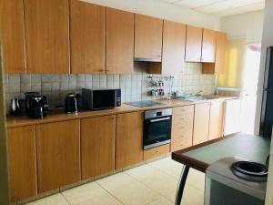 a kitchen with wooden cabinets and a microwave at Stylish Apartment with Spacious Terrace in Aglantzia