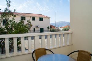 un balcón con mesa y sillas y un edificio en Apartment Lara Iva, en Trogir