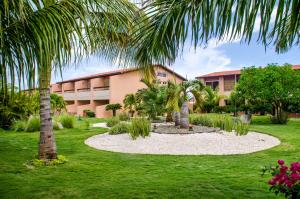 a courtyard with palm trees and a building at Family-Flexication-Friendly Villa, few steps from Eagle Beach in Palm-Eagle Beach