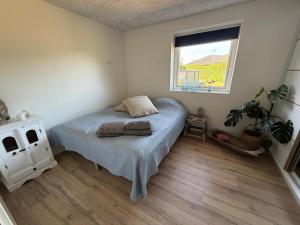 a bedroom with a bed and a window at Hyggeligt hus. in Holstebro