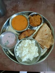 a plate of food with rice and different types of food at Vitthal prema nivas in Sawantwadi