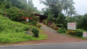 a dirt road with plants on the side of a hill at Vitthal prema nivas in Sawantwadi