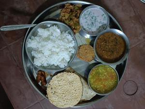 a plate of food with rice and different types of food at Vitthal prema nivas in Sawantwadi +1 photo