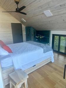 a bedroom with a large bed with a ceiling fan at Sumadijski ranc-Brvnara in Brestovac +16 photos