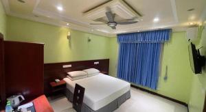 a bedroom with a bed and a ceiling fan at Vista Villa in Hithadhoo