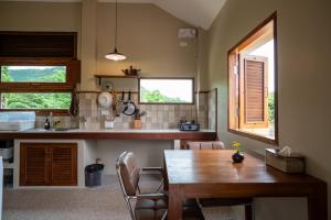 a kitchen with a wooden table and a dining room at The BROWN PAI in Pai