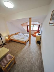 a bedroom with a bed and a chair in a room at Penzion Moyzes in Banská Bystrica