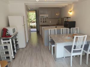 a kitchen with a refrigerator and a table and chairs at MAISON BISCARROSSE LAC 6 pers in Biscarrosse