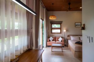 a living room with a couch and a chair at The BROWN PAI in Pai