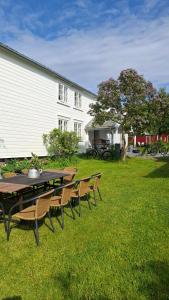 a picnic table and chairs in the grass in front of a building at Handelsstedet Forvik in Vevelstad +15 photos