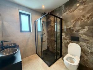 a bathroom with a shower and a toilet and a sink at Vakantierijk Waarland in Waarland