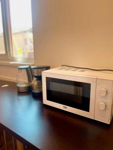 a white microwave sitting on top of a table at Calypso Rooms in Făgăraş