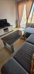 a living room with a table in the middle of a couch at Mista apartment in Peyia +43 photos