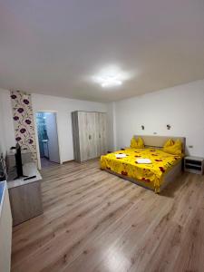 a bedroom with a bed with a yellow blanket at Calypso Rooms in Făgăraş