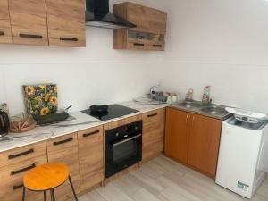 a kitchen with wooden cabinets and a stove and a dishwasher at Hostel in Piotrków Trybunalski